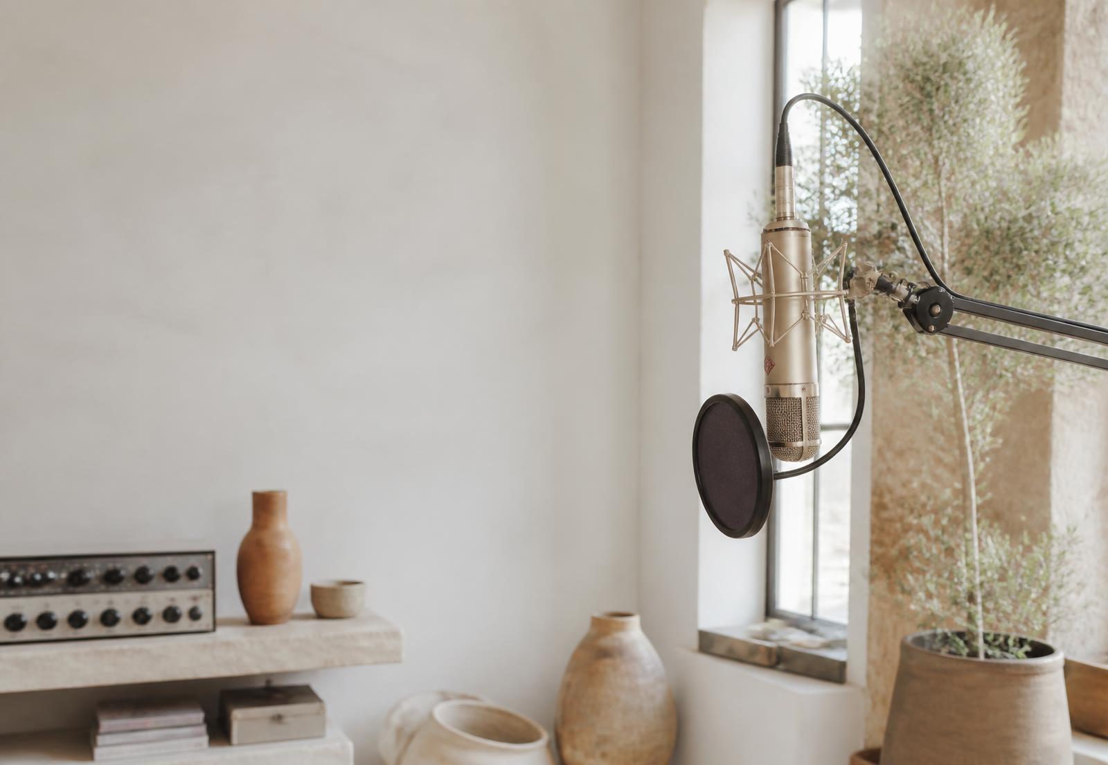 Vintage condenser microphone in a warmly lit recording booth